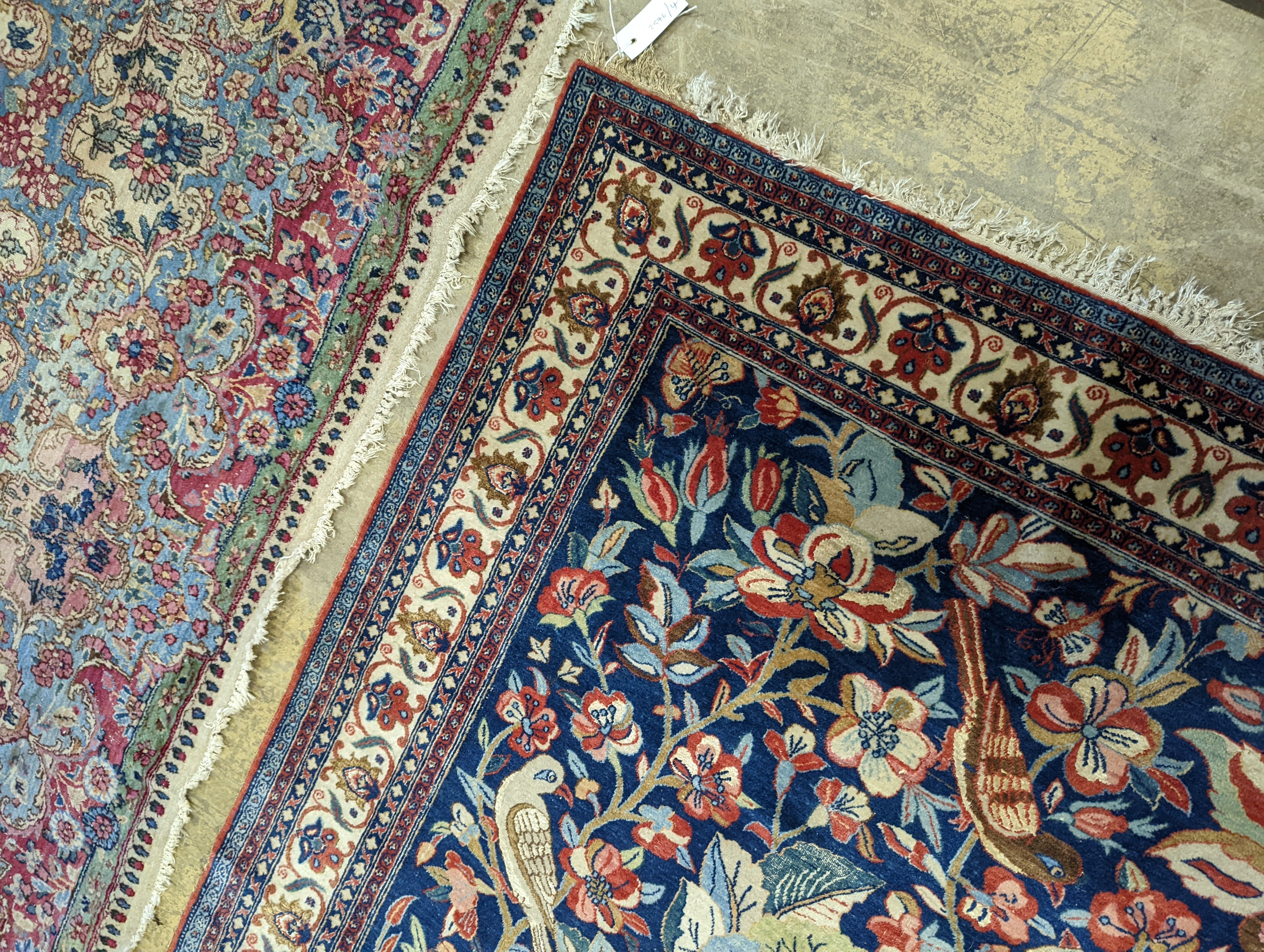 A Kirman blue ground rug woven with birds amongst flowering branches, 205 x 136cm